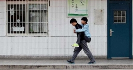 Gražus tikros draugystės pavyzdys: studentas iš Kinijos 3 metus nešioja draugą ant nugaros į užsiėmimus (foto)
